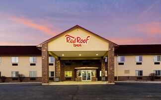 Un Red Roof Inn con fachada de ladrillo, techo plano y una entrada amplia.