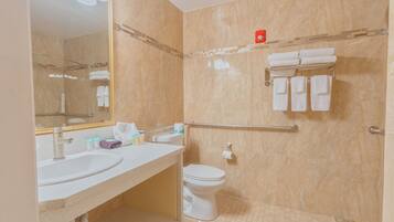 Une salle de bain comprenant un lavabo, des toilettes et un espace douche.