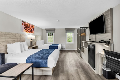 A hotel room with a bed, bedside tables, a desk, a TV, and a wardrobe.. The Northshore Hotel - Boston/Danvers