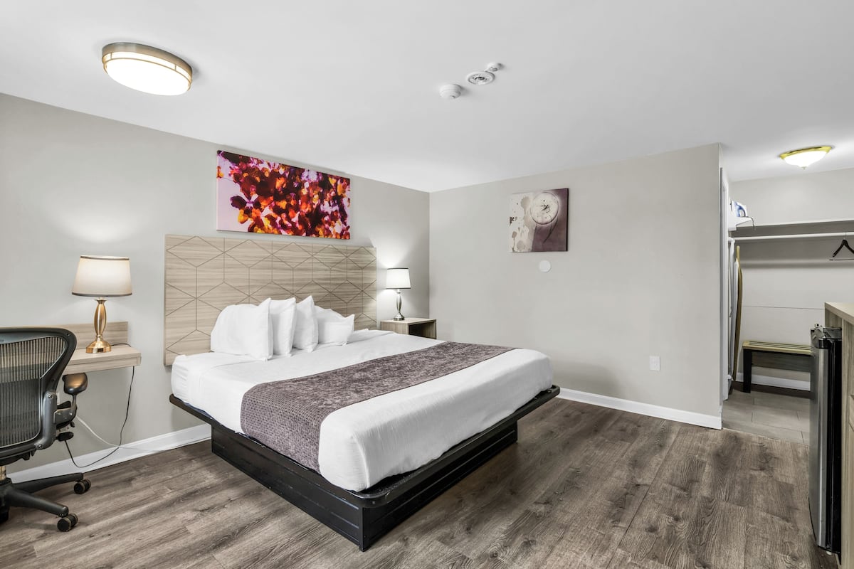 Una habitación de hotel moderna con una cama grande, un escritorio y una silla.