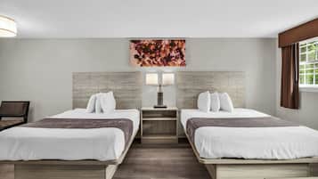 Une chambre d’hôtel avec deux lits, une table de chevet avec une lampe, une œuvre d’art géométrique accrochée au mur et une fenêtre avec des rideaux.