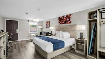 A hotel room with a large bed, bedside tables, a wardrobe, and a view of the outdoors.