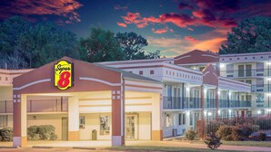 A Super 8 motel with multiple buildings, large windows, and a well-lit facade. - Super 8 by Wyndham Jasper (Jasper)
