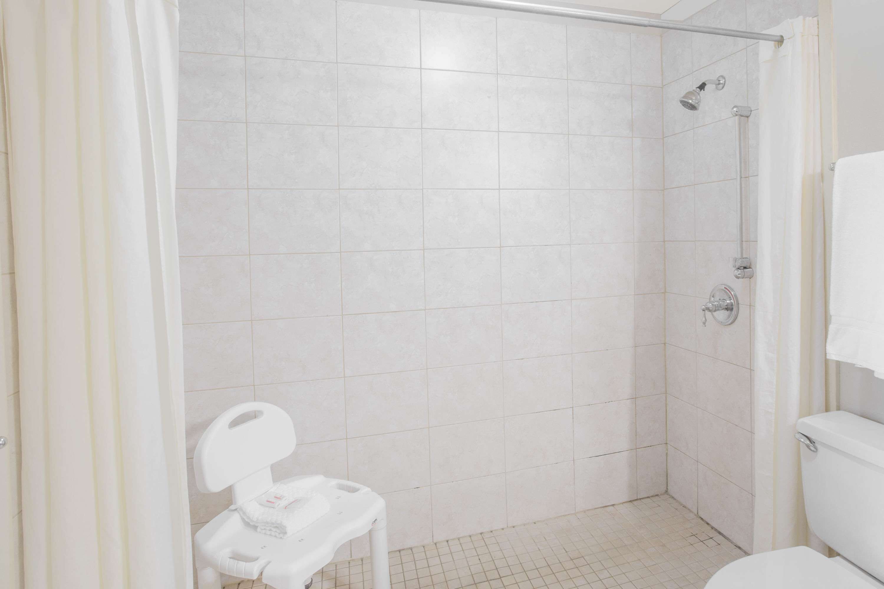 Une petite salle de bain moderne, équipée d’une douche, de toilettes et d’un petit lavabo.
