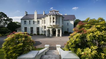 A large, stately building with a prominent entrance, a driveway, and well-maintained landscaping.