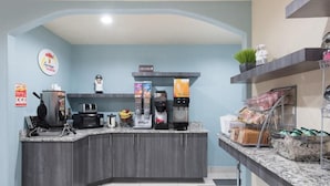 Cocina moderna con una estación de café integrada, microondas y cafetera.