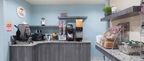 Cocina moderna con una estación de café integrada, microondas y cafetera.