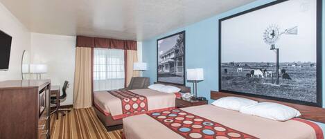 A hotel room with two beds, a desk, a chair, and a large window with a windmill picture.