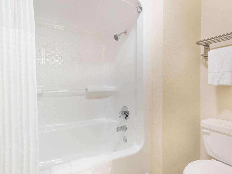 A bathroom with a bathtub, a toilet, and a towel rack.