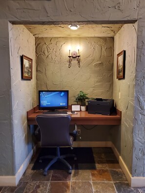 A home office setup with a desk, computer, chair, and two framed pictures on the walls. - Super 8 by Wyndham Troy (Troy)
