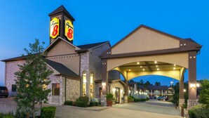A hotel with a prominent 'Super 8' sign, a covered entrance, and a brick facade.