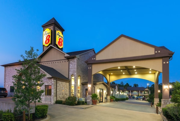 A hotel with a prominent 'Super 8' sign, a covered entrance, and a brick facade.