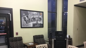 A conference room with a large framed Texas state map, two patterned chairs, a table, and a computer station.