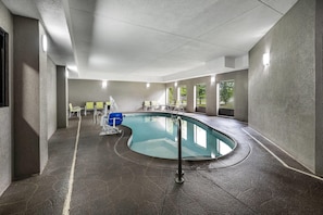Una piscina de borde curvo, rodeada de muros con textura.