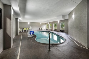 Una piscina de borde curvo, rodeada de muros con textura.