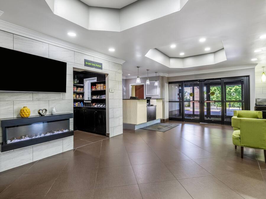 A spacious lobby with a flat-screen TV, a reception desk, and a fire feature.