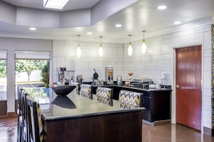 A modern kitchen with a central island, pendant lighting, and a view of the outdoors.