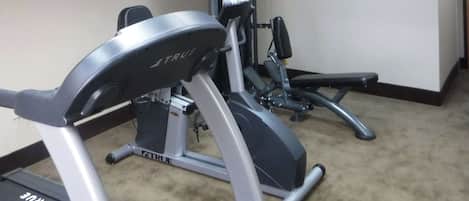 A gym with treadmills and a bench press.