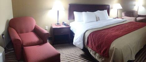 A hotel room with a bed, two nightstands, a chair, and a lamp.