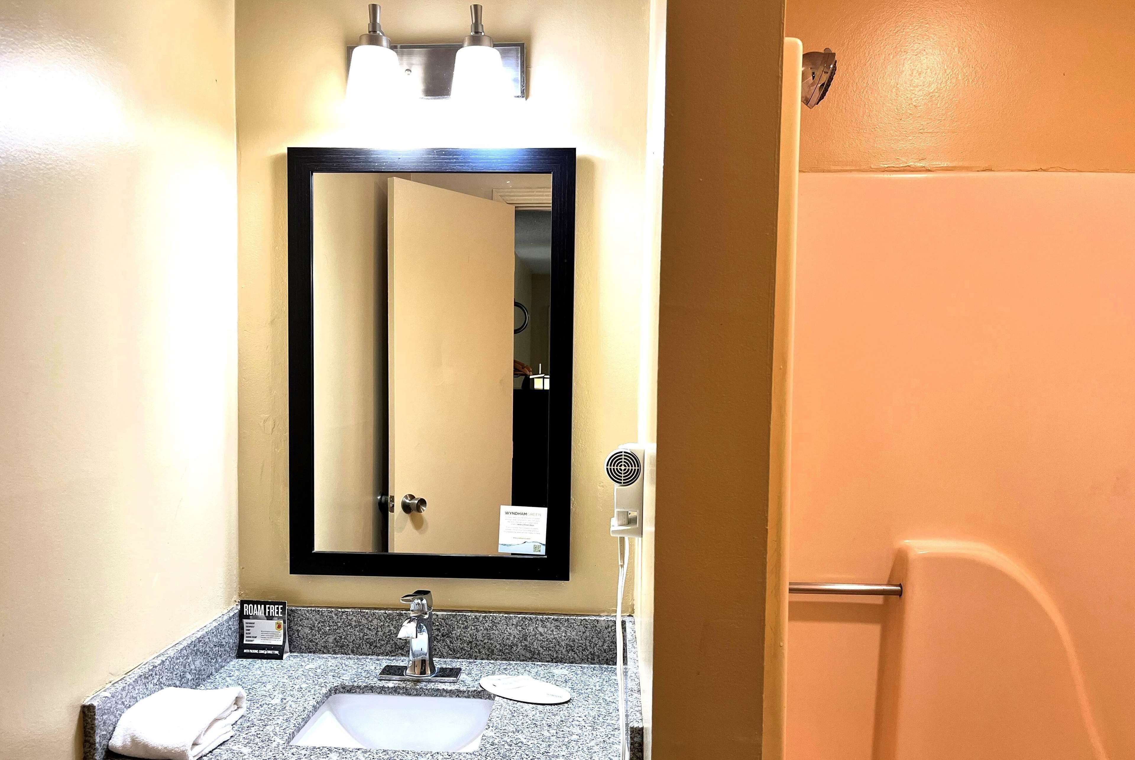 A bathroom with a sink, mirror, and towel rack.