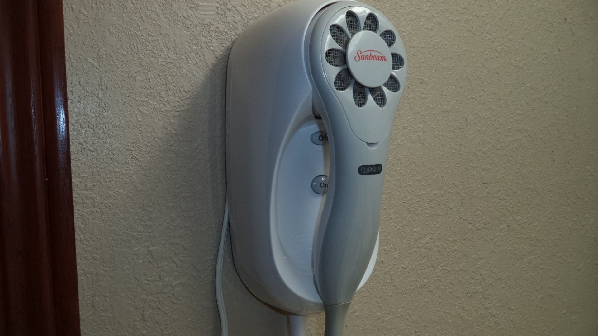 A wall-mounted device with a circular fan and a control panel, labeled "Sunbeam."