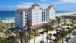 Hotel met uitzicht op het strand, meerdere parkeerlagen en een opvallend 'Four Points' bord.