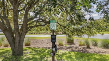 A charging station for electric cars with a sign indicating it is for electric car parking only while charging.