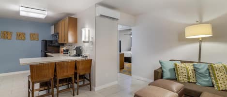 A modern apartment with a kitchen, dining area, and living room.