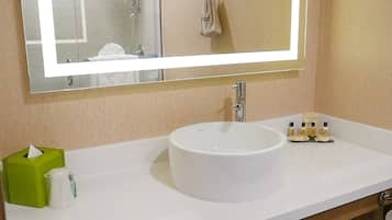 Une salle de bain avec un lavabo blanc, un miroir et un porte-serviettes.