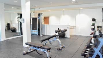 A gym with exercise equipment, including a bench and dumbbells.