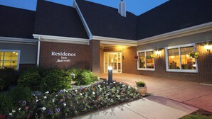 Ein Backsteinhaus mit einem Schild, auf dem "Residence Inn Marriott" steht, und einem gepflegten Blumenbeet davor.