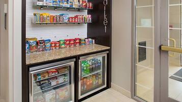 Un refrigerador con refrigerios y bebidas, abastecido con variedad de productos como papas fritas, cereales y refrescos.
