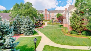 A residential area with a well-maintained lawn, a pathway, and a brick building with multiple windows. - Residence Inn by Marriott Saddle River (Saddle River)