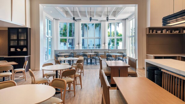 Un vaste espace dédié à la salle à manger, doté de hauts plafonds, de grandes fenêtres et de mobilier moderne.