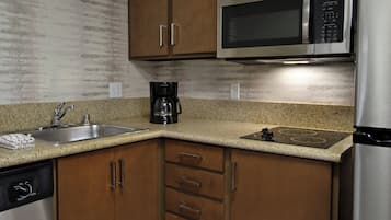A kitchen with wooden cabinets, stainless steel appliances, a granite countertop, and a dishwasher.
