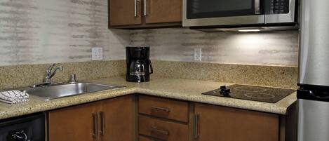 A kitchen with wooden cabinets, stainless steel appliances, a granite countertop, and a dishwasher.