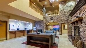 A spacious lobby with a reception desk, seating area, stone walls, and a fireplace. - La Quinta Inn & Suites by Wyndham Vancouver (Vancouver)