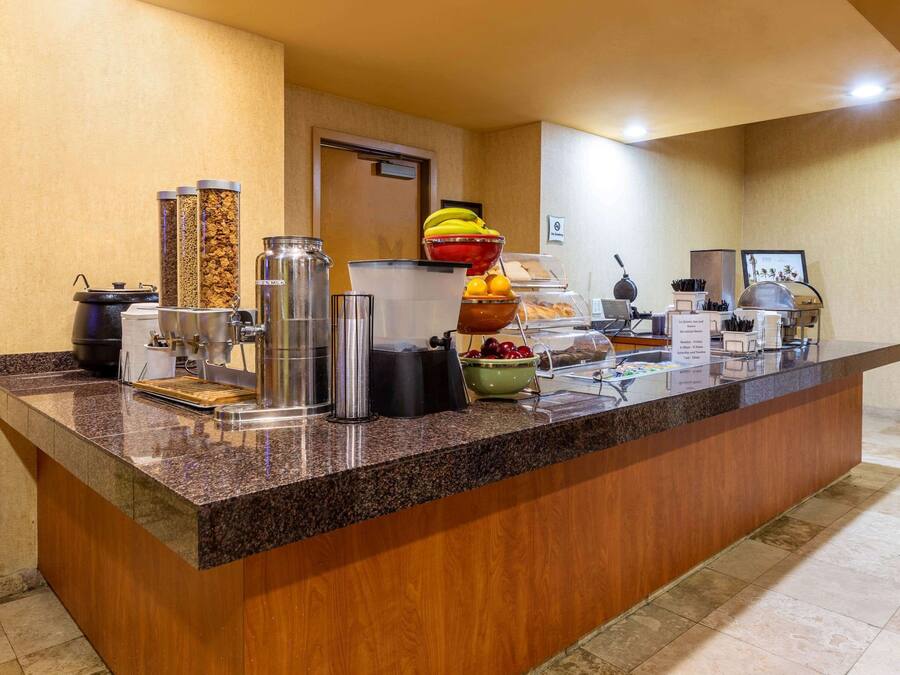 Un comptoir de buffet proposant divers plats et contenants, notamment un saladier de fruits et un espace dédié au café.