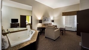 A hotel room with a large bathtub, a sofa, a small table, and a window with curtains. - Sleep Inn & Suites Valdosta Mall Area (Valdosta)