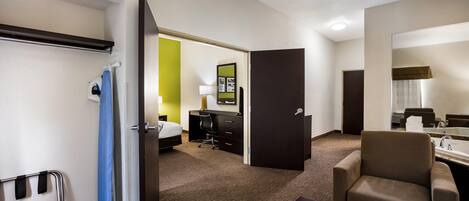 Habitación de hotel con cama, escritorio, silla y baño.