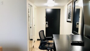 A conference room with a long table, a black office chair, and a door leading to another room. - Quality Inn & Suites Lake Charles South (Lake Charles)