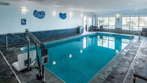 Ein Hallenbad mit gut sichtbarer Beschilderung, einem Dienstplan für Rettungsschwimmer und einer Schwimmhilfe.