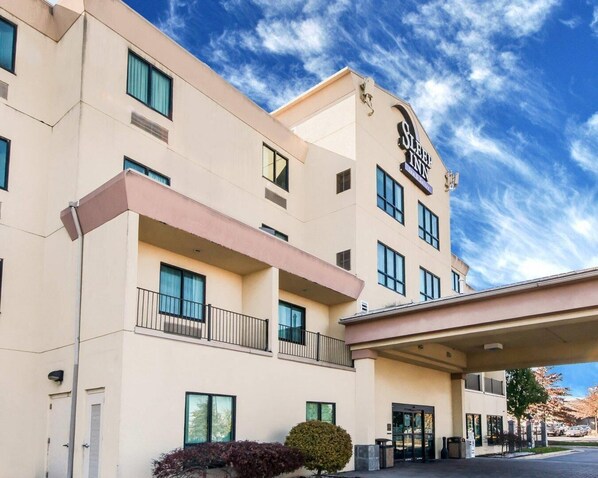 A hotel with a modern design, featuring a prominent sign, multiple balconies, and a covered entrance area.