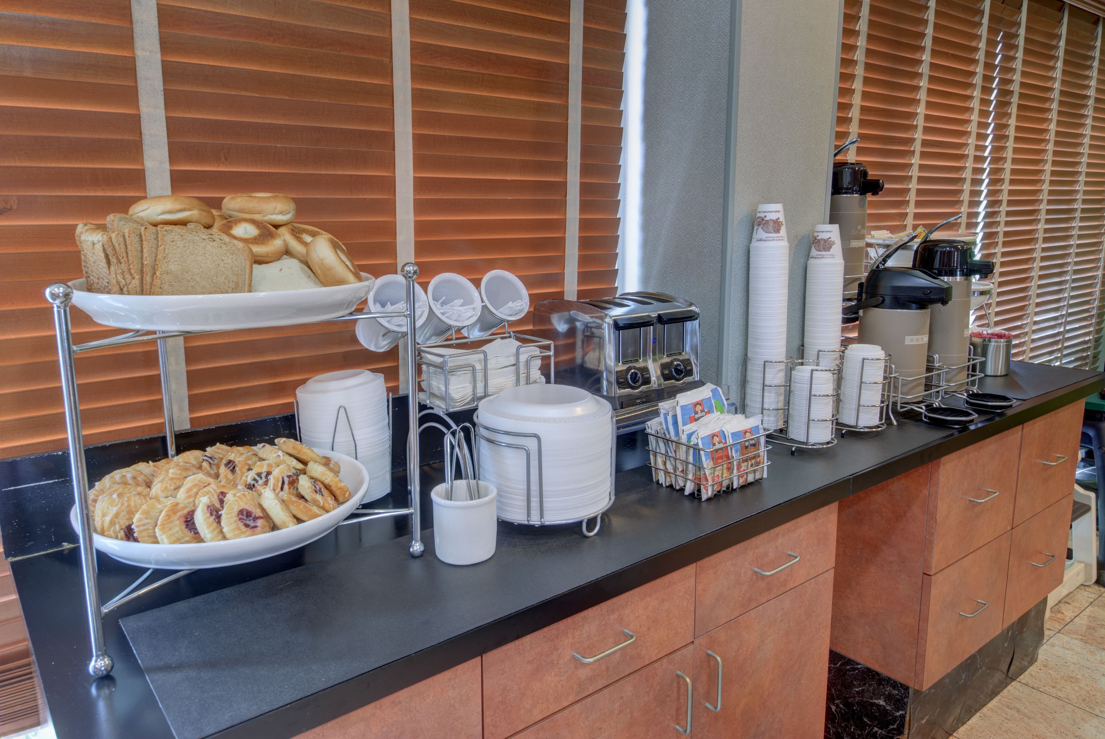 A buffet setup with various food items and breakfast beverages.