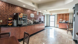 Eine moderne Hotelhalle mit Empfangsschalter, Kaffeeangebot und einer Sitzecke.