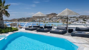 Una piscina al aire libre de temporada, sillones reclinables de piscina