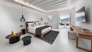Un dormitorio moderno con cama, mesitas de noche, un escritorio y un ventanal que ofrece vistas.