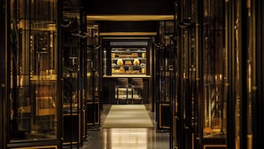 A corridor with glass doors leading to a reception area with a counter and seating. - Duxton Reserve Singapore, Autograph Collection (Singapore)