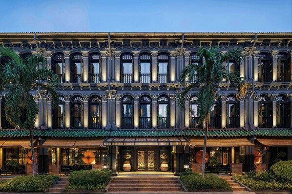 Un edificio de varios pisos con detalles arquitectónicos ornamentales, incluyendo columnas y molduras decorativas.