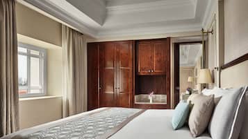 A hotel room with a large bed, wooden wardrobe, and a window with curtains.